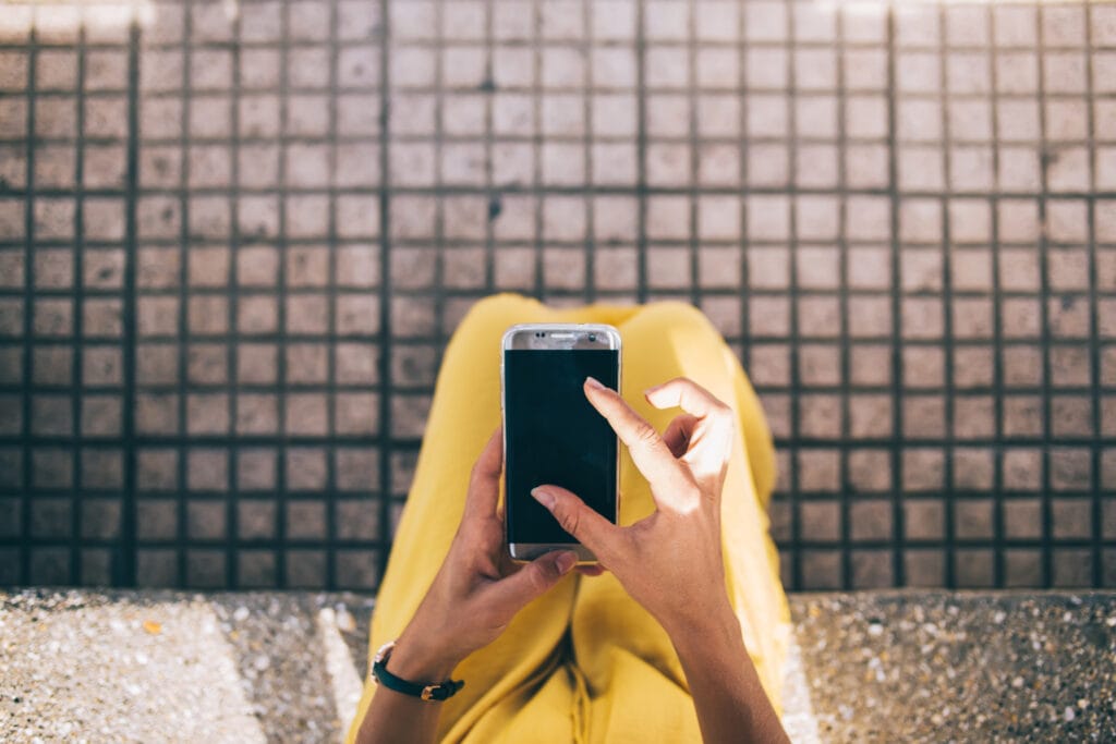 puhelin kädessä. Kuvituskuva